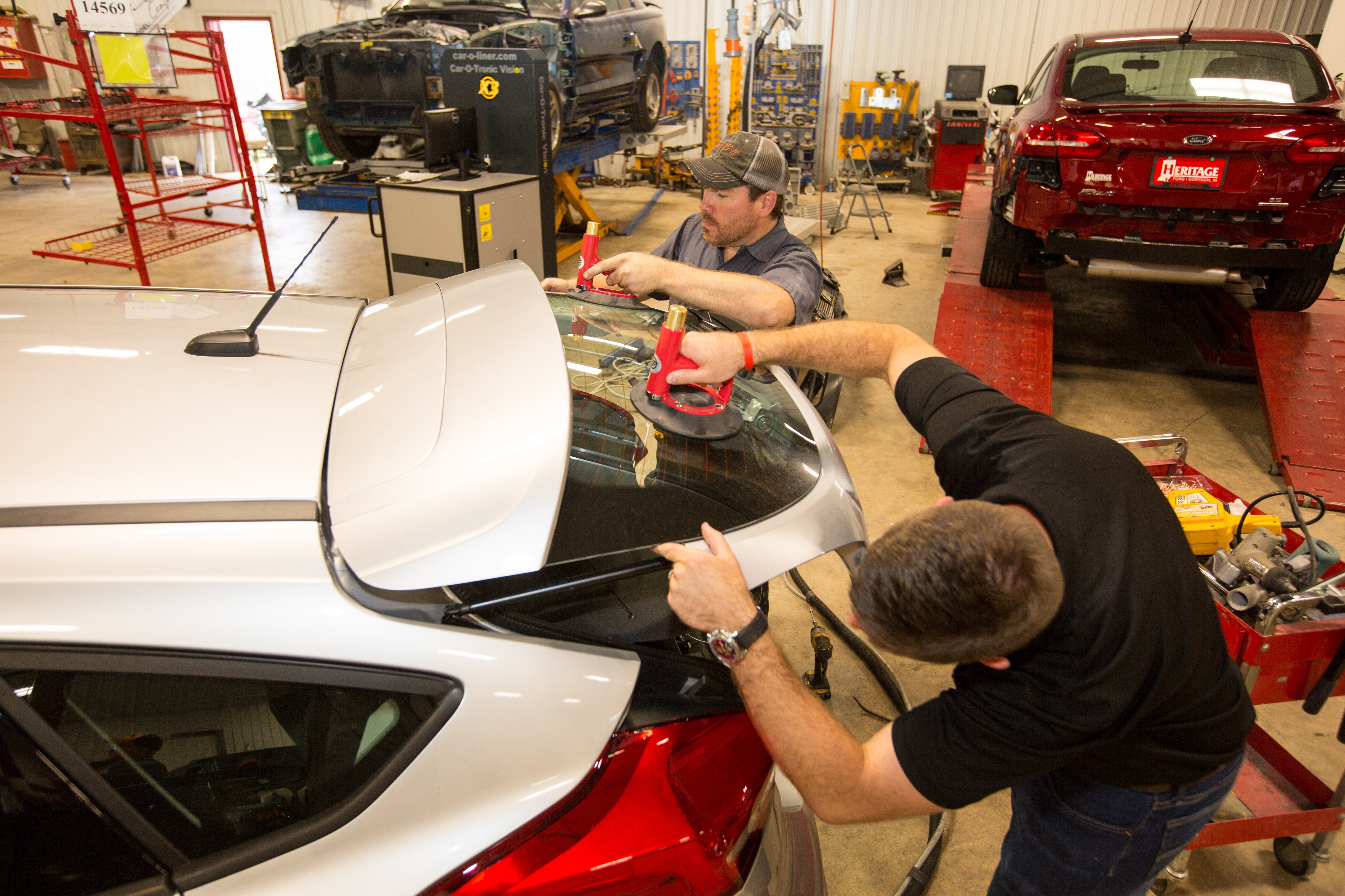 Two men repairing auto glass